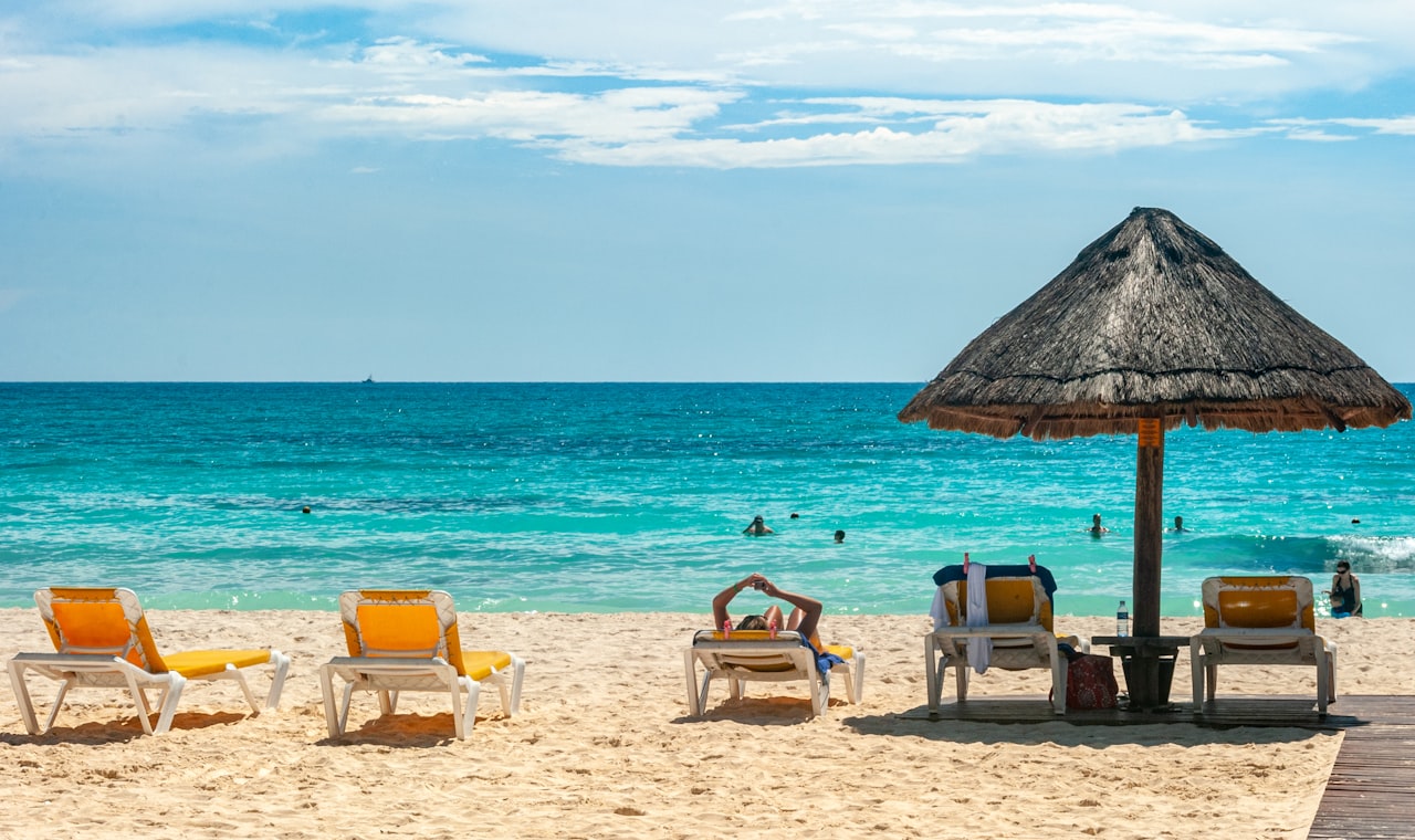 Cancún — brown beach umbrellas on beach during daytime