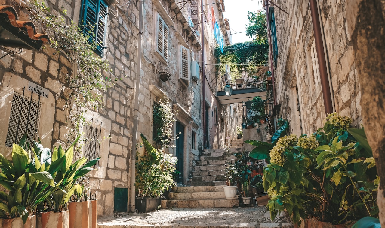 Dubrovnik — a narrow alleyway with potted plants on either side
