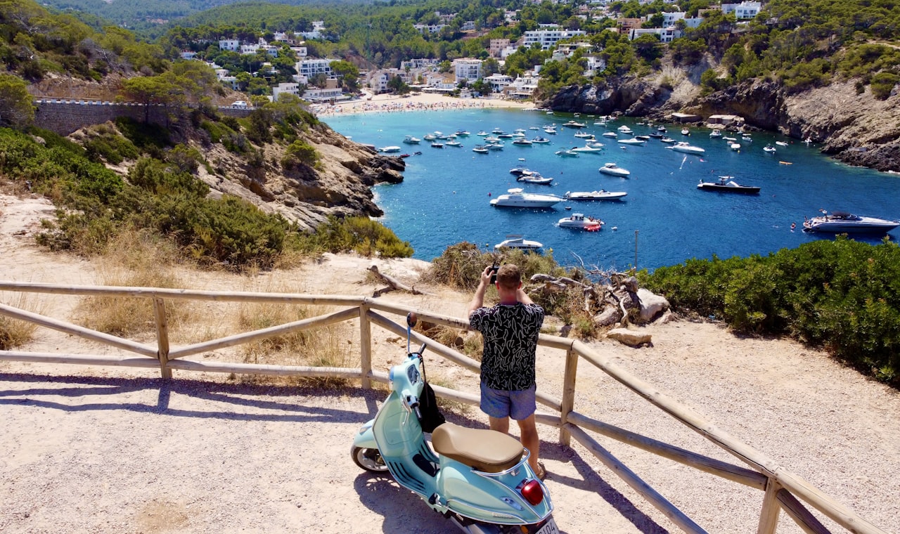 Ibiza — a person on a scooter looking at boats in the water